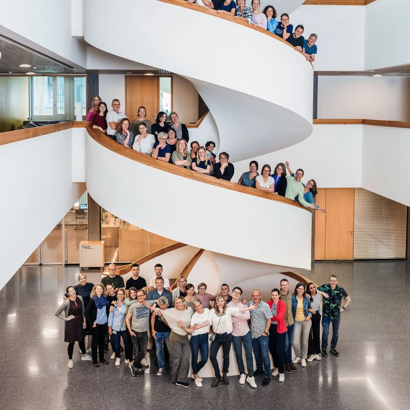XUND team photo in modern office spiral staircase - employee survey and pulse survey tool implementation case study